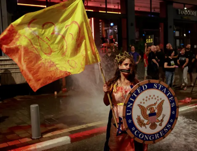 A protester seen outside the US embassy office in Tel Aviv