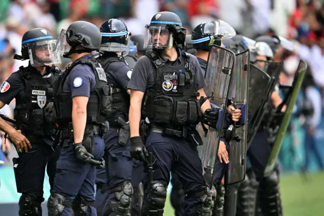 Riot police holding batons and shields