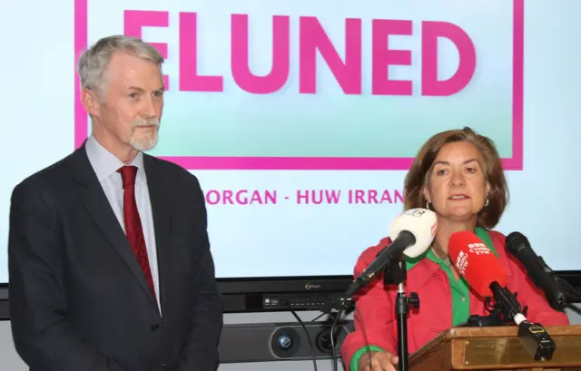 Eluned Morgan with Huw Irranca-Davies at the Royal Welsh Show, in front of a screen showing their names