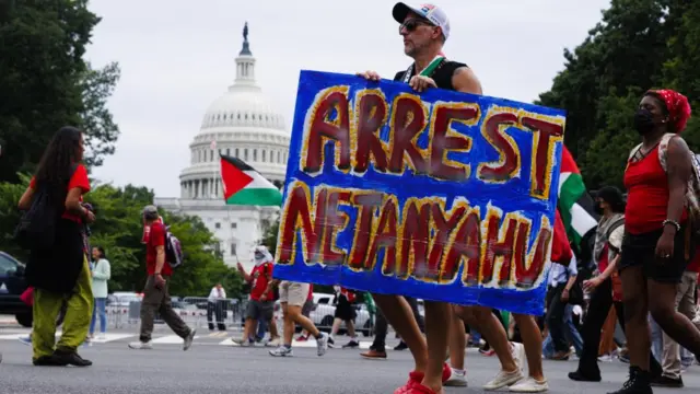 Protester with "Arrest Netanyahu" sign