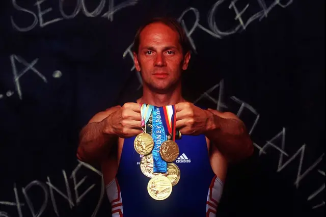 Steve Redgrave holds up his five gold medals