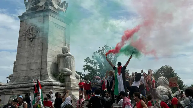 Protesters with green and red smoke