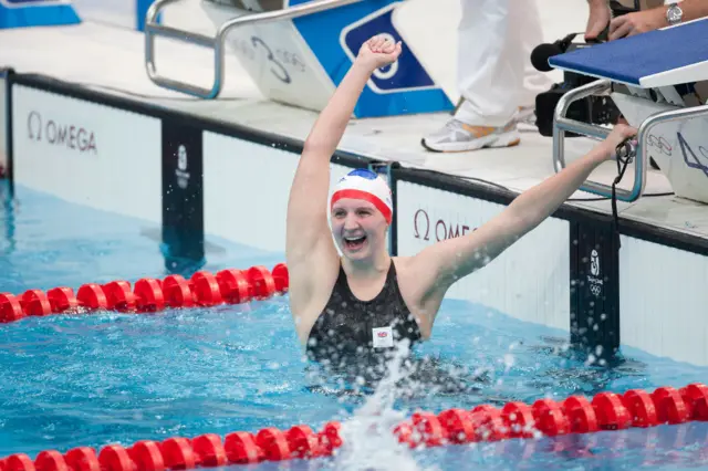 Rebecca Adlington throws up her arms at the edge of the swimming pool