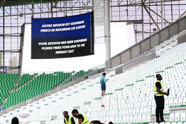 A big screen in the Stade Geoffroy-Guichard stadium displaying the message "your session has been suspended please make your way to the nearest exit"