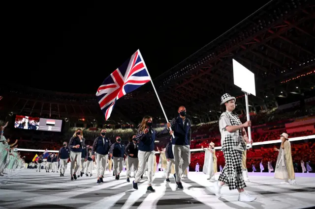 Hannah Mills and Mohamed Sbihi hold up the Team GB flag at Tokyo 2020