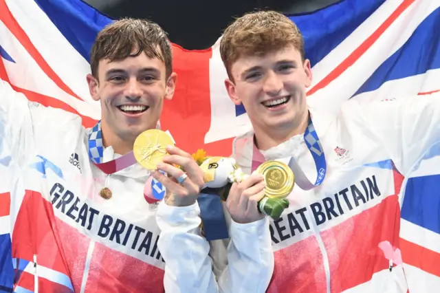 Tom Daley And Matty Lee hold up gold medals