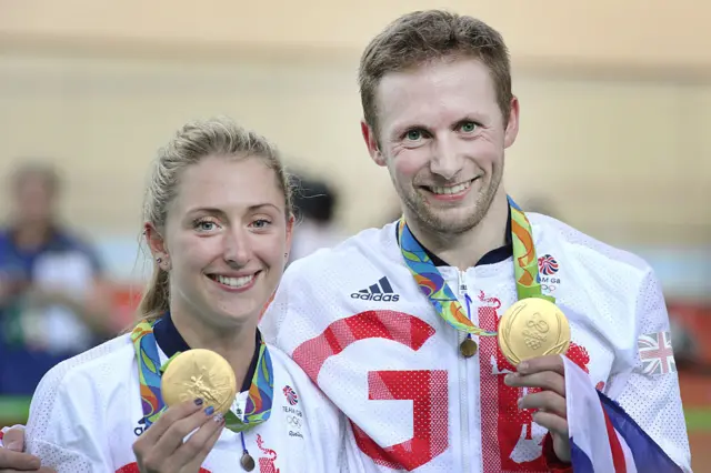 Laura Trott and Jason Kenny hold up their gold medals