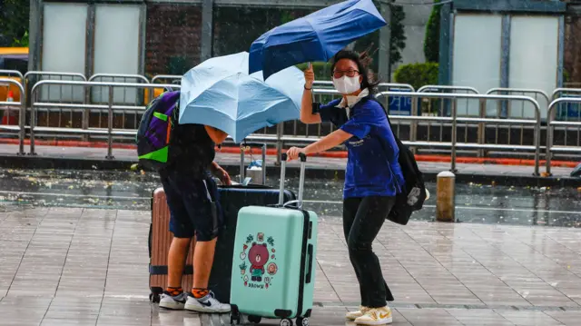 People battle against strong wind in Taipei, Taiwan.