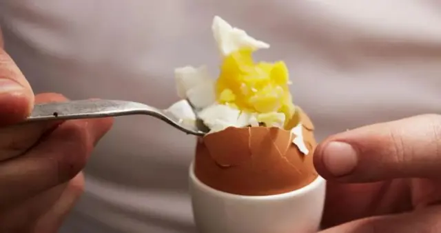 A spoon holds some egg