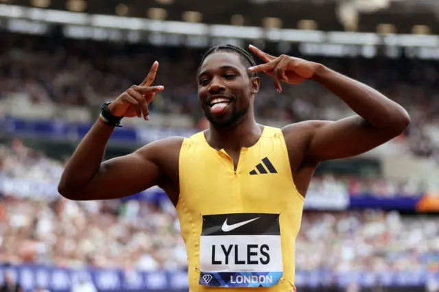 Noah Lyles holds up his hands in celebration