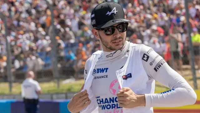 Esteban Ocon adjusts his overalls