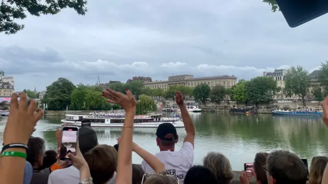 Spectators wave at the athletes