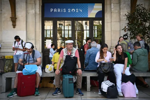 Passengers sitting around with their suitcases in at Bordeaux train station