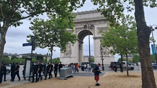 The Arc de Triomphe. It's empty apart from a line of police walking away from it.