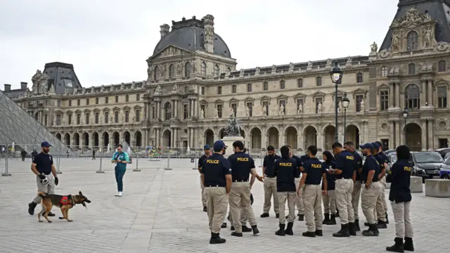 Police officers and a K-9 unit gather near the Louvre Museum.