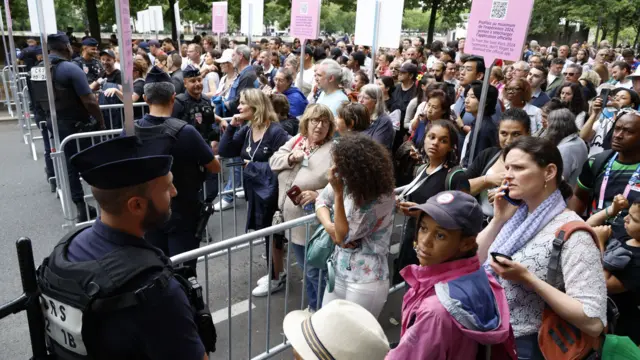 Spectators make their way through security checks ahead of the opening ceremony.