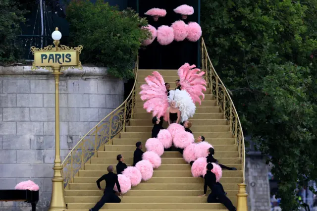 Lady Gaga rehearses on a set of steps with dancers in Paris