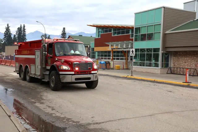 A fire truck drives by a school in Jasper