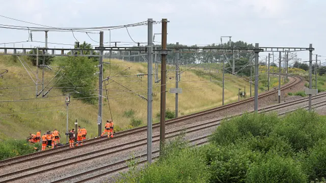 SNCF employees inspect the scene of a suspected attack on the high speed railway network at Croiselles, northern France