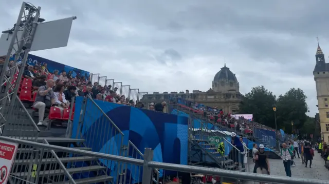 Spectators take their seats by the River Seine