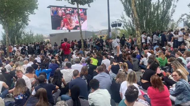 Crowds gather by the River Seine