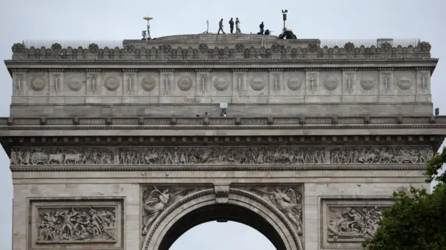 Security personnel stationed above the Arc de Triomphe in Paris.