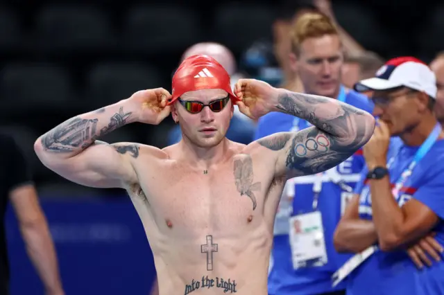 Adam Peaty adjusting his swimming cap