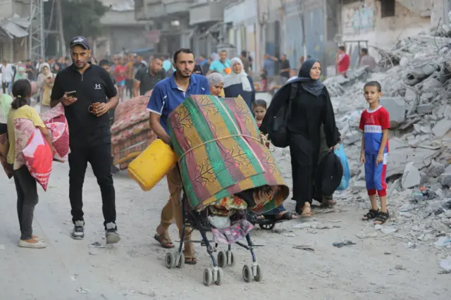 Palestinians, including children evacuate the area after the Israeli army announced that "an operation will be organized" at the Bureij refugee camp in Deir al-Balah, Gaza, on July 28