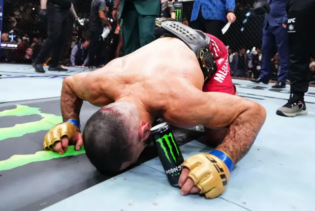 Belal Muhammad prays in the cage after winning the UFC belt