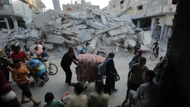 Palestinians, including children evacuate the area after the Israeli army announced that "an operation will be organized" at the Bureij refugee camp in Deir al-Balah, Gaza, on July 28. Palestinians migrate to the areas they thought to be safe as they also carry their belongings.