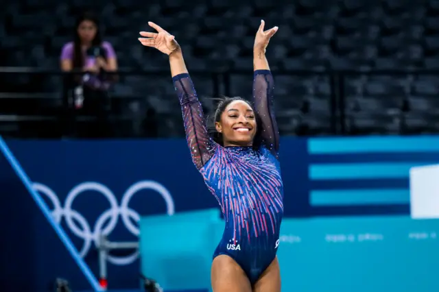 Simone Biles posing with her hands in the air