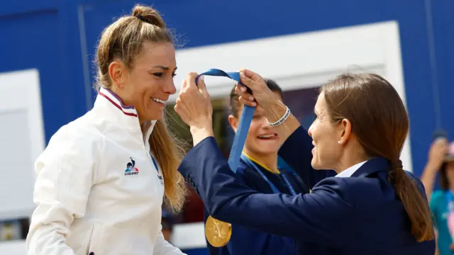 Gold medallist Pauline Ferrand Prevot of France is presented with her medal on the podium