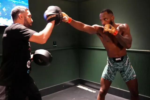 Leon Edwards warms up on the pads backstage