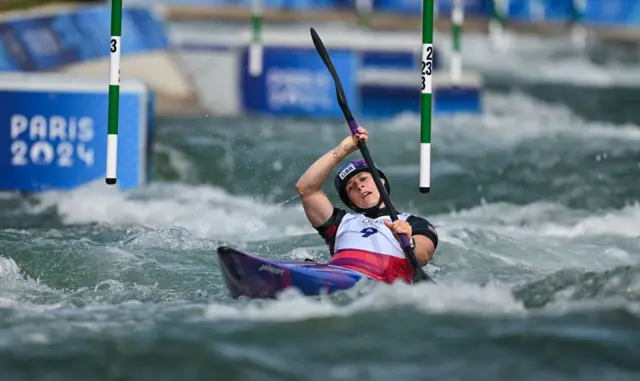 Woods paddles through a gate during the canoe final