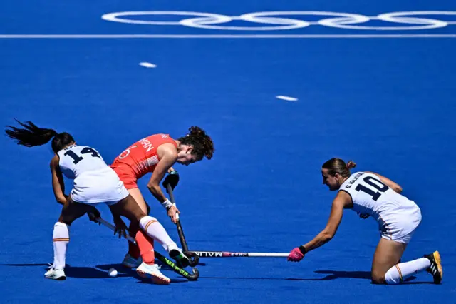 Spain's Blanca Perez and Belen Iglesias fighting for the ball with Britain's Anna Toman