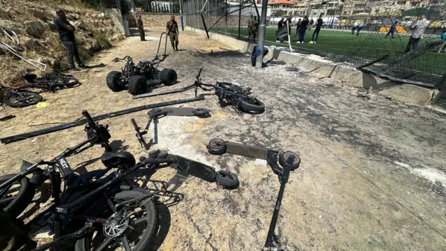 Broken bikes lying just outside the football pitch