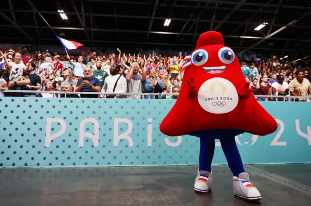 Phryges, the Olympic mascot, entertaining the crowd at the handball event.