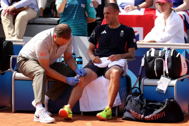 Dan Evans wincing in pain as he gets treatment