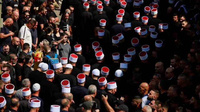 People gather during the funeral of children who were killed at a soccer pitch by a rocket