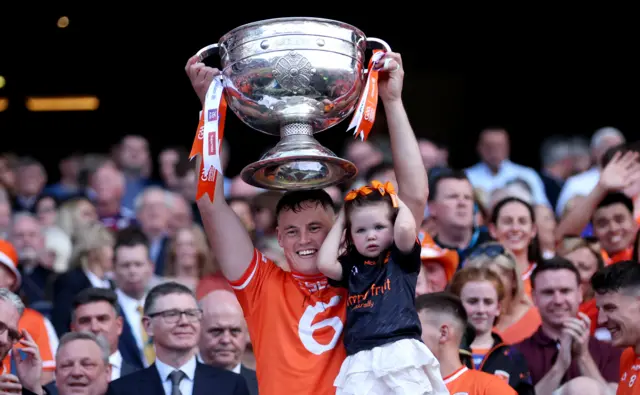 Aaron McKay and his daughter Nova lift the Sam Maguire