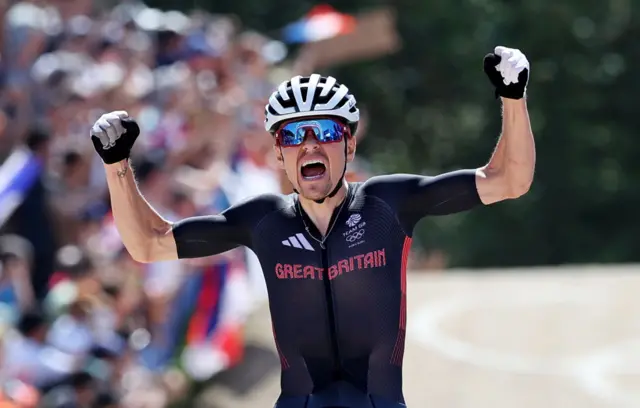 Tom Pidcock celebrates as he crosses the line