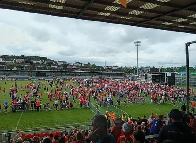 Crowds in orange and white on a green pitch