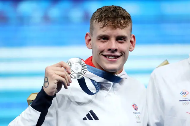 Matt Richards holds up his silver medal