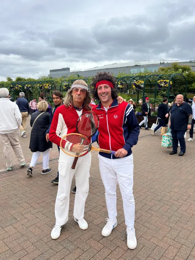 Two men dressed up in costume posing for a picture.