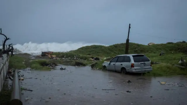 Tall waves near a flooded car