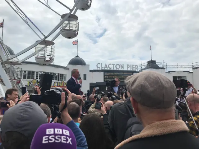 Nigel Farage is seen above a crowd of people at the front of Clacton Pier