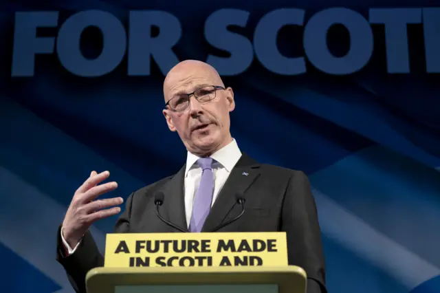 John Swinney at an SNP lecturn