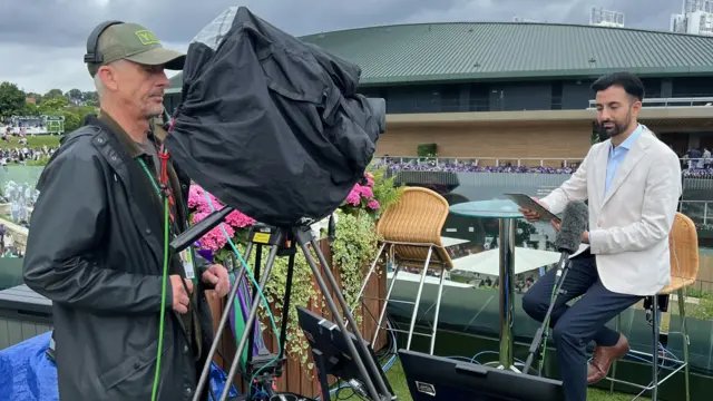 Presenter sat down on a stool facing a camera