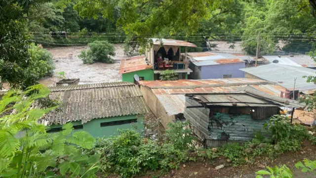 View of flooded houses after a river swelled due to heavy rains following the passage of Hurricane Beryl on the road from Cumana to Cumanacoa, Sucre State