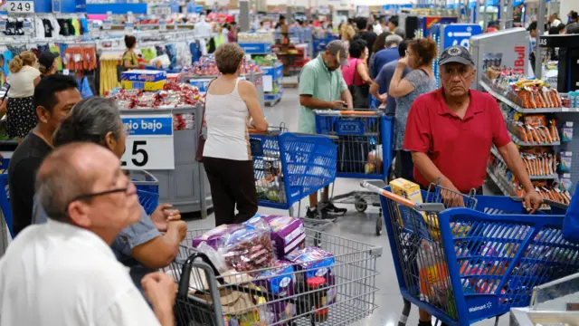 People queue to buy goods at a supermarket